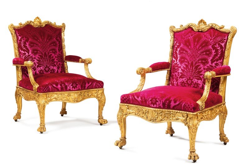 A pair of giltwood armchairs with crimson silk upholstery, among the French furniture from the H&ocirc;tel Lambert.
