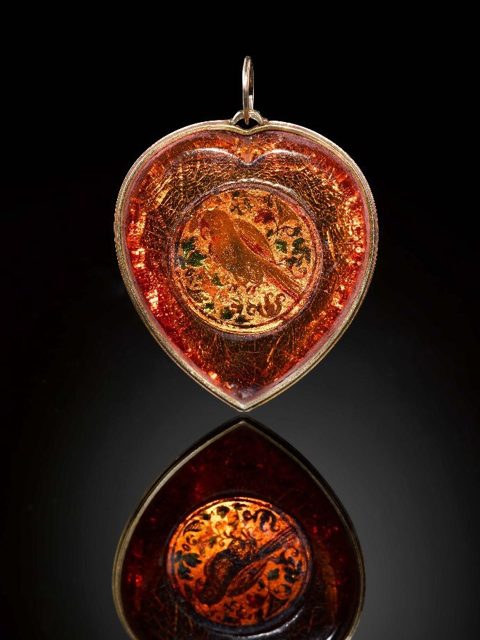 The heart-shaped amber pendant, with a popinjay carved on the reverse