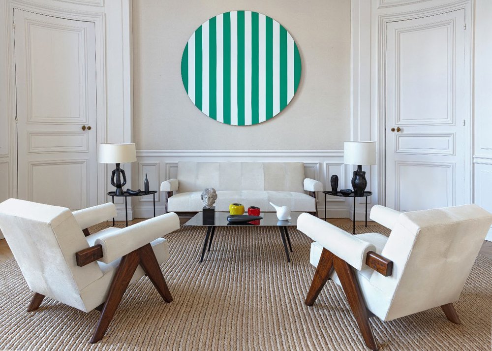 Daniel Buren’s Cercle Coloré Vert above a pair of Charlotte Perriand chairs, with Georges Jouve table lamps.